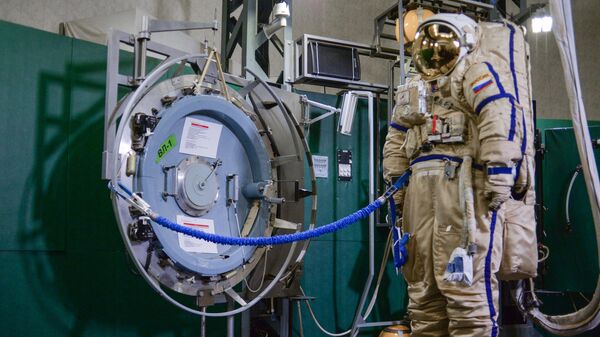 Выходной люк ВЛ-1 одного из модулей Международной космической станции и российский скафандр для работы в открытом космосе Орлан МК в Центре подготовки космонавтов имени Ю. А. Гагарина