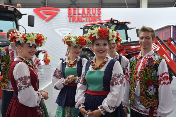 Молодые люди в национальных костюмах на стенде Республики Беларусь на международной промышленной выставке Иннопром-2023 в Екатеринбурге