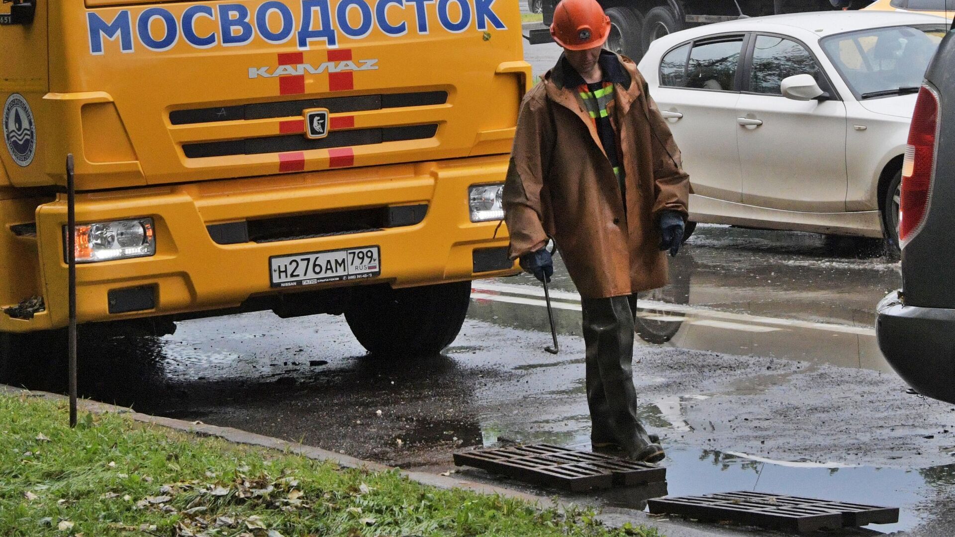 Сотрудник ГУП Мосводосток осматривает ливневую канализацию в Москве во время дождя - РИА Новости, 1920, 18.06.2024