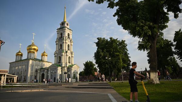 Молодой человек катается на самокате на территории Тульского Кремля. На заднем плане - Свято-Успенский собор и Соборная колокольня