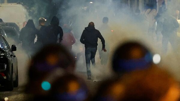 Участники протестов во Франции убегают от сотрудников полиции в Париже 