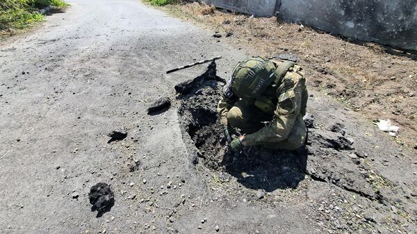 Сотрудник Совместного центра контроля и координации вопросов, связанных с военными преступлениями Украины (СЦКК) на месте обстрела