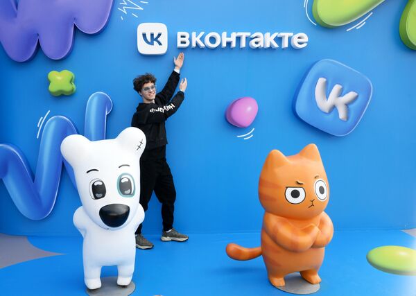Молодой человек фотографируется на фоне арт-объекта на фестивале VK FEST 2023 в Центральном парке культуры и отдыха имени Горького в Москве