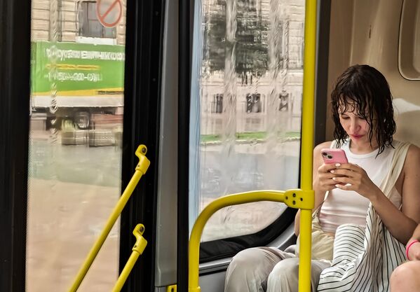 Девушка в автобусе во время дождя в Москве
