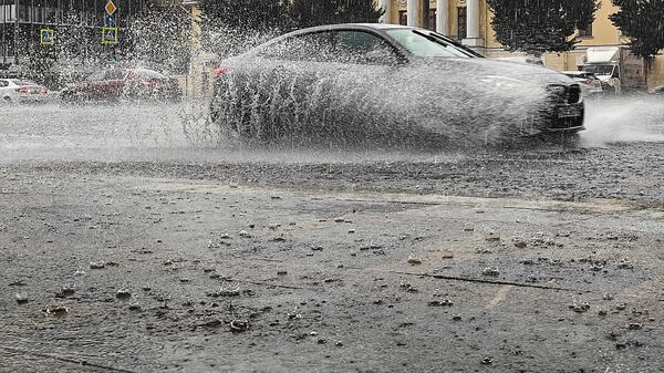 Автомобиль едет по Садовому кольцу во время сильного дождя в Москве