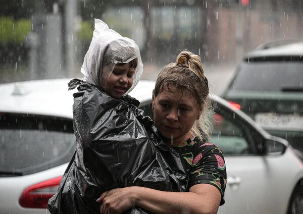 Женщина с ребенком во время дождя в Москве