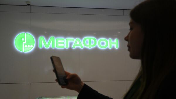 Девушка со смартфоном в офисе компании Мегафон в Москве