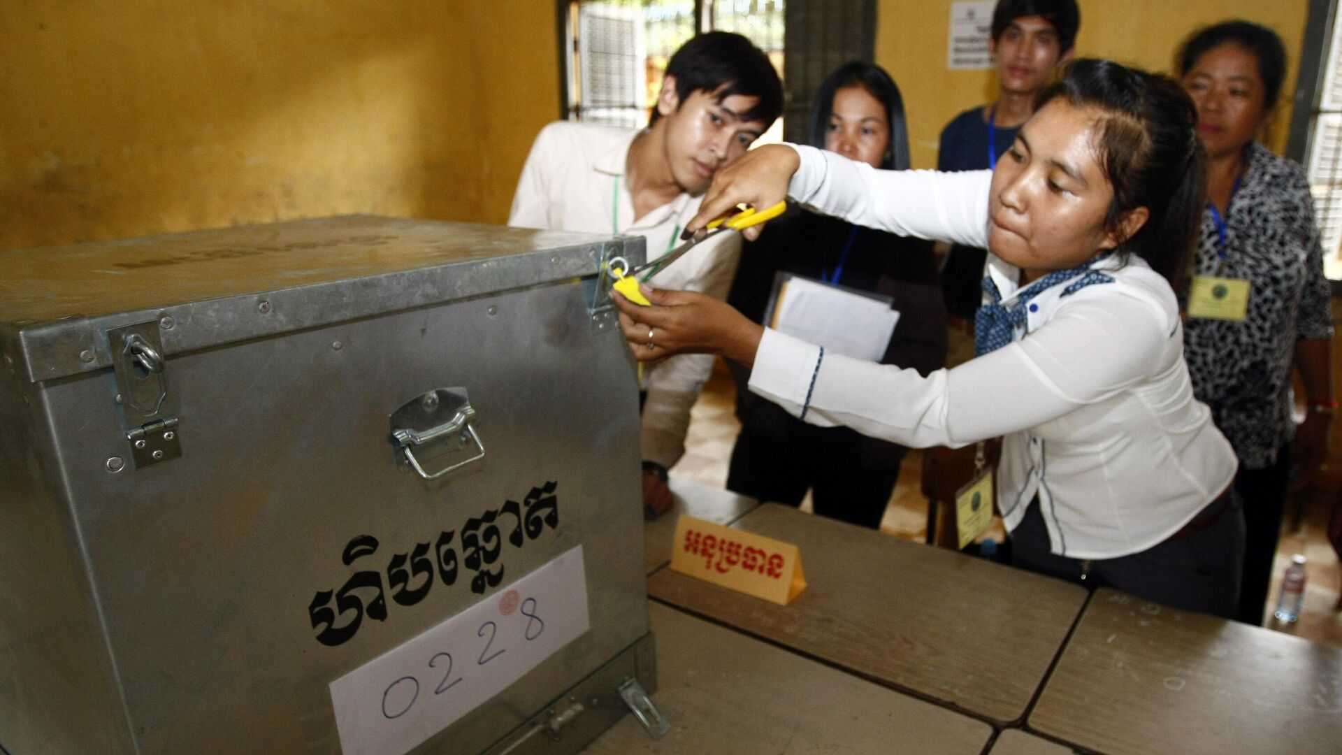 Представитель избирательной комиссии открывает урну для подсчета голосов на избирательном участке в  Пномпене в Камбодже - РИА Новости, 1920, 05.08.2023