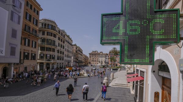 В Риме люди проходят мимо вывески, которая показывает температуру воздуха, 18 июля 2023 года