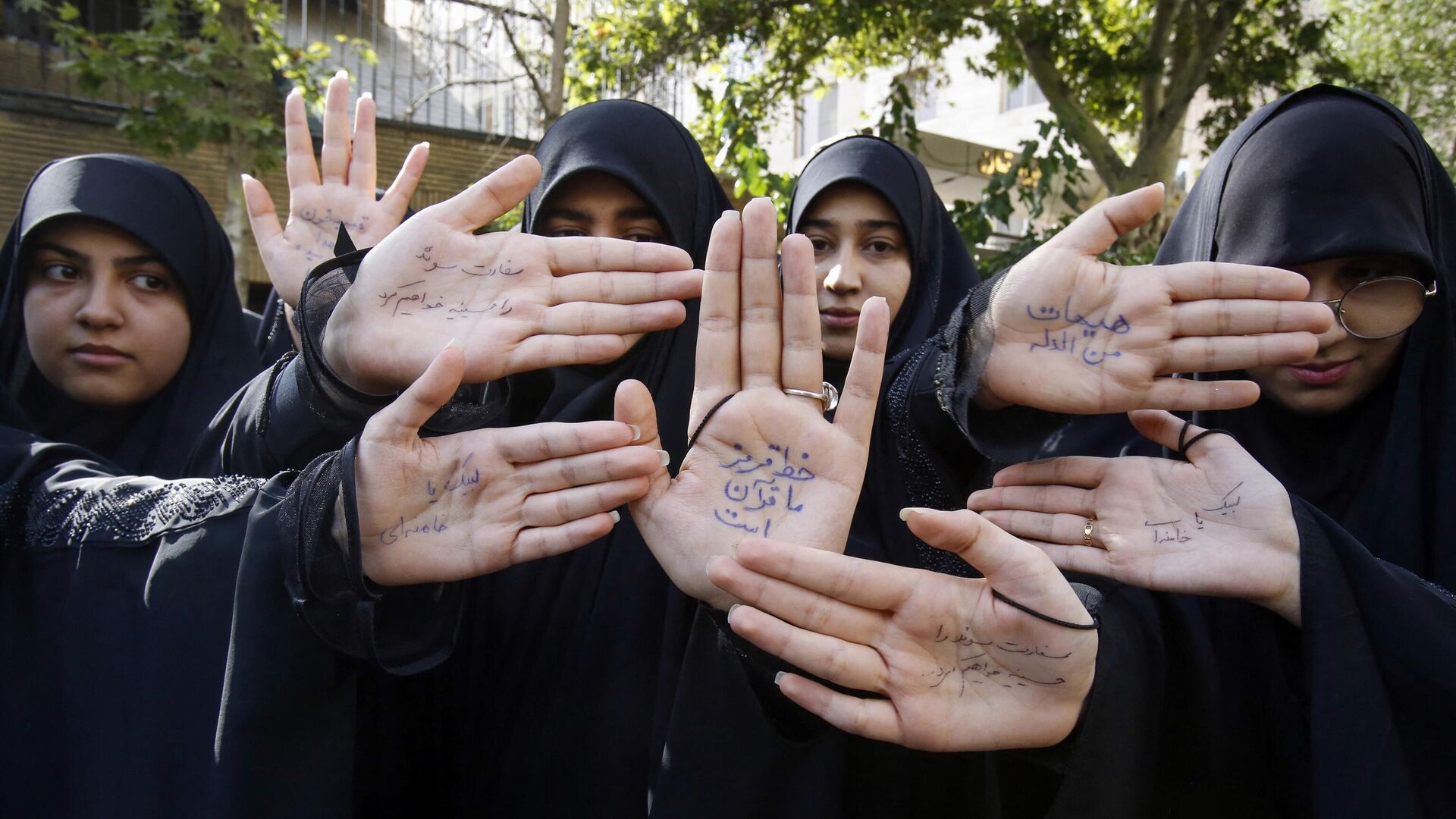 Иранские студенты с лозунгами, написанными на их руках, во время демонстрации в Тегеране, осуждающей сожжение в Швеции Корана - РИА Новости, 1920, 21.07.2023
