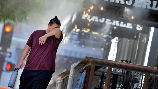 Мужчина вытирает лоб во время жары в Фениксе