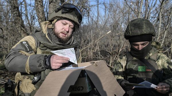 Военный корреспондент медиагруппы Россия сегодня Ростислав Журавлев (слева) разбирает присланные письма для бойцов на передовой, участвующих в боевых действиях на Запорожском направлении