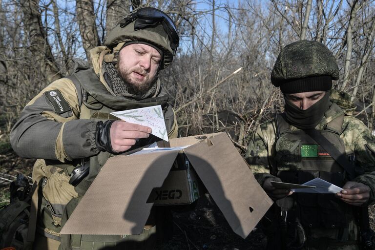 Военный корреспондент медиагруппы Россия сегодня Ростислав Журавлев (слева) разбирает присланные письма для бойцов на передовой, участвующих в боевых действиях на Запорожском направлении