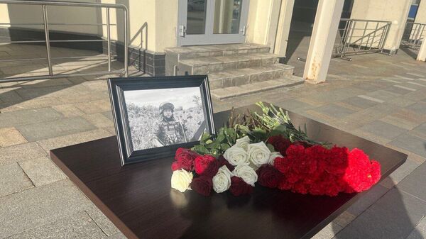 Фотография погибшего военкора РИА Новости Ростислава Журавлева у здания МИА Россия сегодня