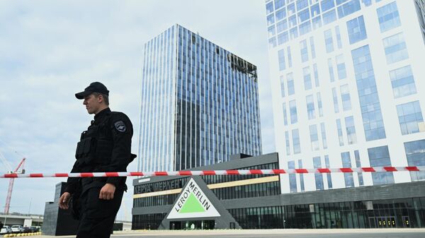 Сотрудник полиции у здания бизнес-центра на проспекте Лихачева в Москве, поврежденного беспилотником