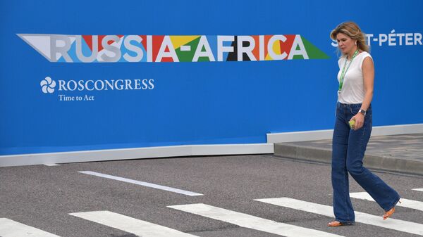 Женщина проходит на фоне баннеров, приуроченных ко II Саммиту, экономическому и гуманитарному форуму Россия - Африка в Санкт-Петербурге