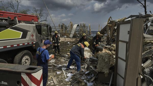 Сотрудники аварийно-спасательных служб работают на месте разрушенного здания в порту Одессы