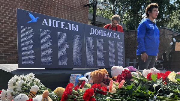 Цветы и игрушки у стенда с именами детей, погибших из-за обстрелов Донбасса со стороны ВСУ