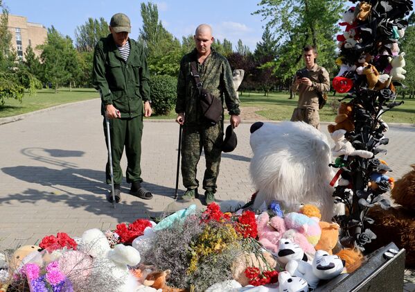 Люди у мемориала в память о детях, погибших из-за обстрелов Донбасса вооруженными силами Украины, на Аллее ангелов в парке Ленинского Комсомола в Донецке