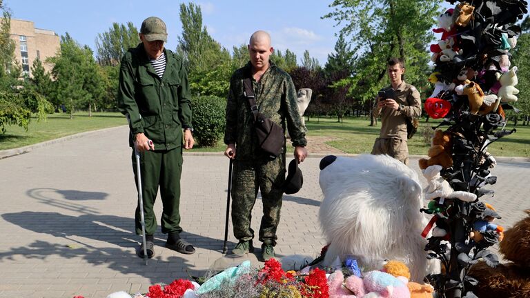 Люди у мемориала в память о детях, погибших из-за обстрелов Донбасса вооруженными силами Украины, на Аллее ангелов в парке Ленинского Комсомола в Донецке