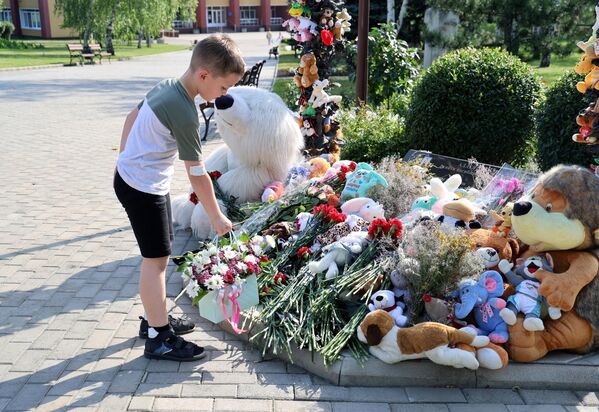 Мальчик возлагает цветы к мемориалу в память о детях, погибших из-за обстрелов Донбасса вооруженными силами Украины, на Аллее ангелов в парке Ленинского Комсомола в Донецке
