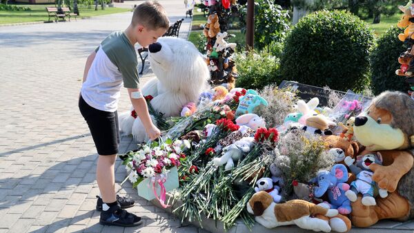 Мальчик возлагает цветы к мемориалу в память о детях, погибших из-за обстрелов Донбасса вооруженными силами Украины, на Аллее ангелов в парке Ленинского Комсомола в Донецке
