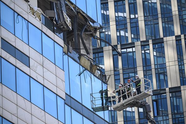 Работники следственных органов осматривают повреждения в здании делового центра Москва-сити