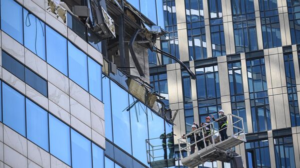 Работники следственных органов осматривают повреждения в здании делового центра Москва-сити