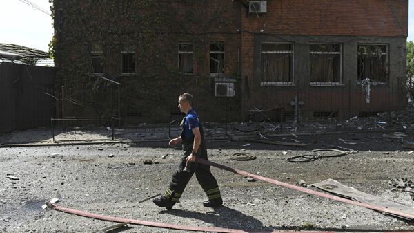 Пожарный у дома, разрушенного в результате обстрела Донецка со стороны ВСУ