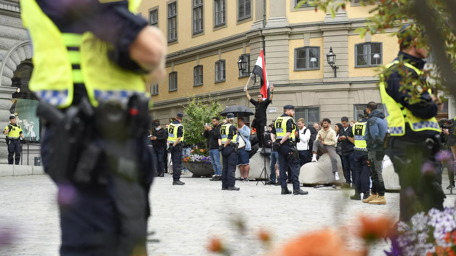 Полицейское оцепление и люди с флагом Ирака недалеко от здания швецкого парламента в Стокгольме. 31 июля 2023 - РИА Новости, 1920, 31.07.2023