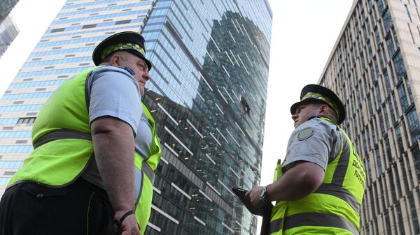 Сотрудники правоохранительных органов у одной из башен Москва-Сити, получившей повреждения при атаке беспилотника