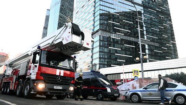 Машины спецслужб у одной из башен Москва-Сити, поврежденной при атаке беспилотника
