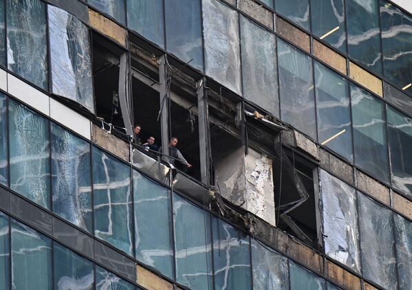 Сотрудники следственного комитета в башне IQ-квартал делового центра Москва-сити, поврежденной в результате атаки украинских беспилотников