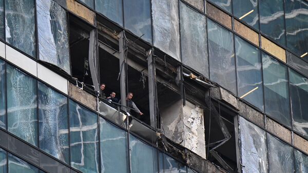 Сотрудники следственного комитета в башне IQ-квартал делового центра Москва-сити, поврежденной в результате атаки украинских беспилотников