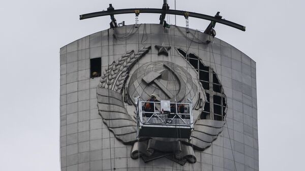 Рабочие демонтируют герб СССР с монумента Родина-мать в Киеве, Украина
