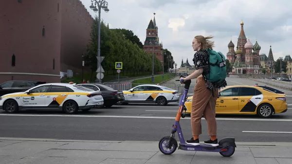 Девушка катается на самокате возле Красной площади в Москве