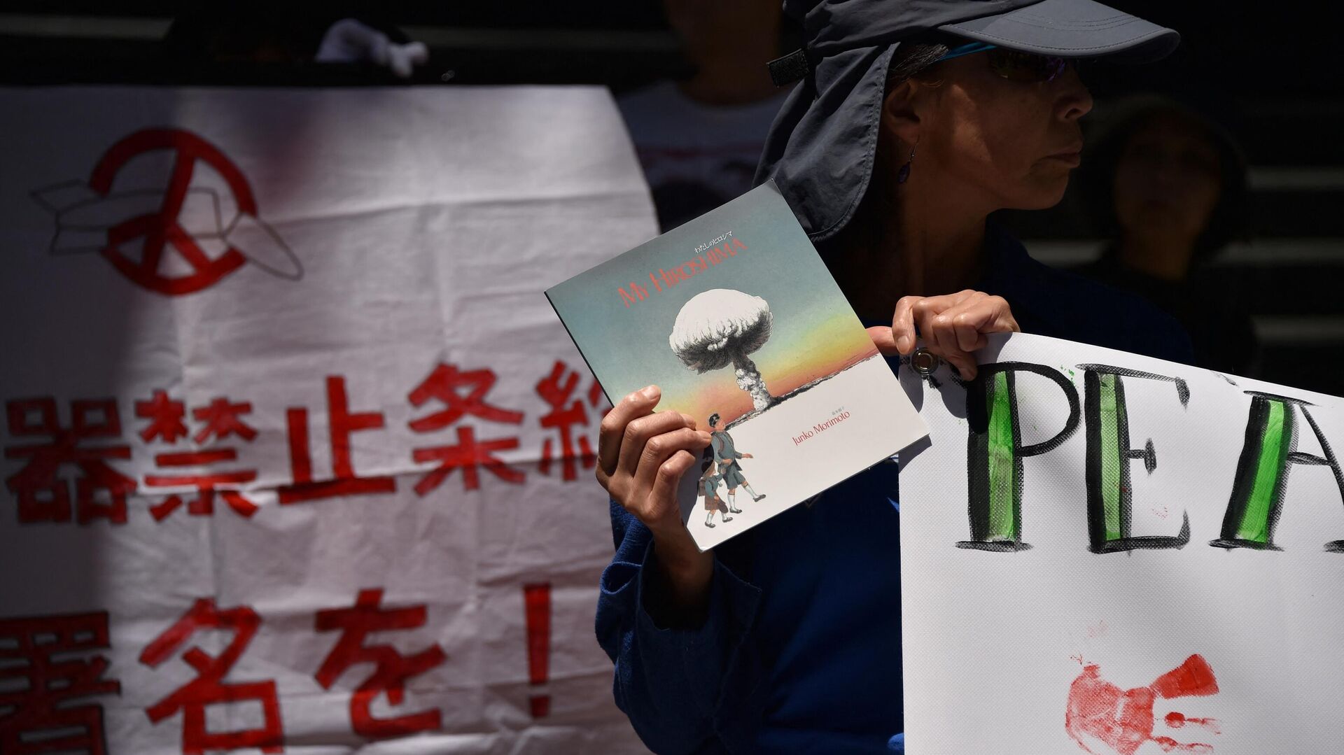 Участник митинга против ядерного оружия с книгой Дзюнко Моримото Моя Хиросима - РИА Новости, 1920, 06.08.2023