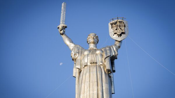 Рабочие устанавливают герб Украины на монумент Родина-мать в Киеве