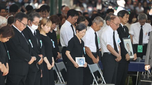 Участники соблюдают минуту молчания во время церемонии памяти жертв атомной бомбардировки Хиросимы