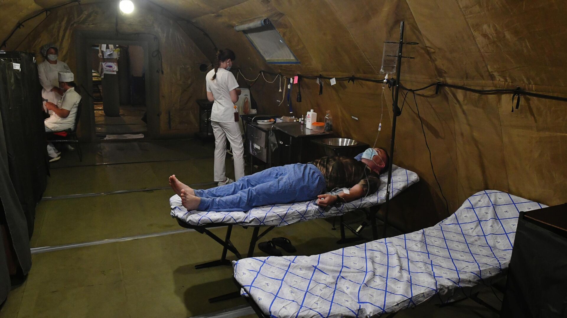 Медики и военнослужащий в палатке полевого госпиталя в зоне специальной военной операции на Украине0