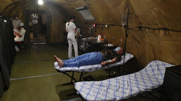 Медики и военнослужащий в палатке полевого госпиталя в зоне специальной военной операции на Украине