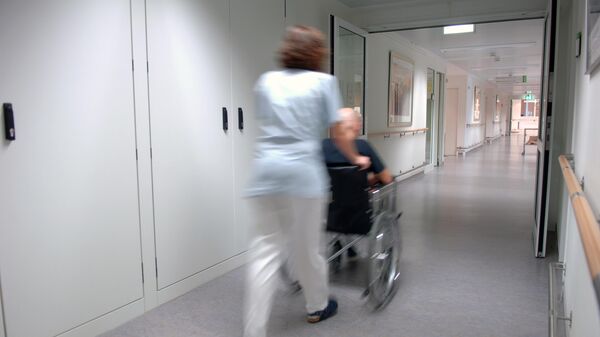 Медсестра с пациентом в коридоре больницы