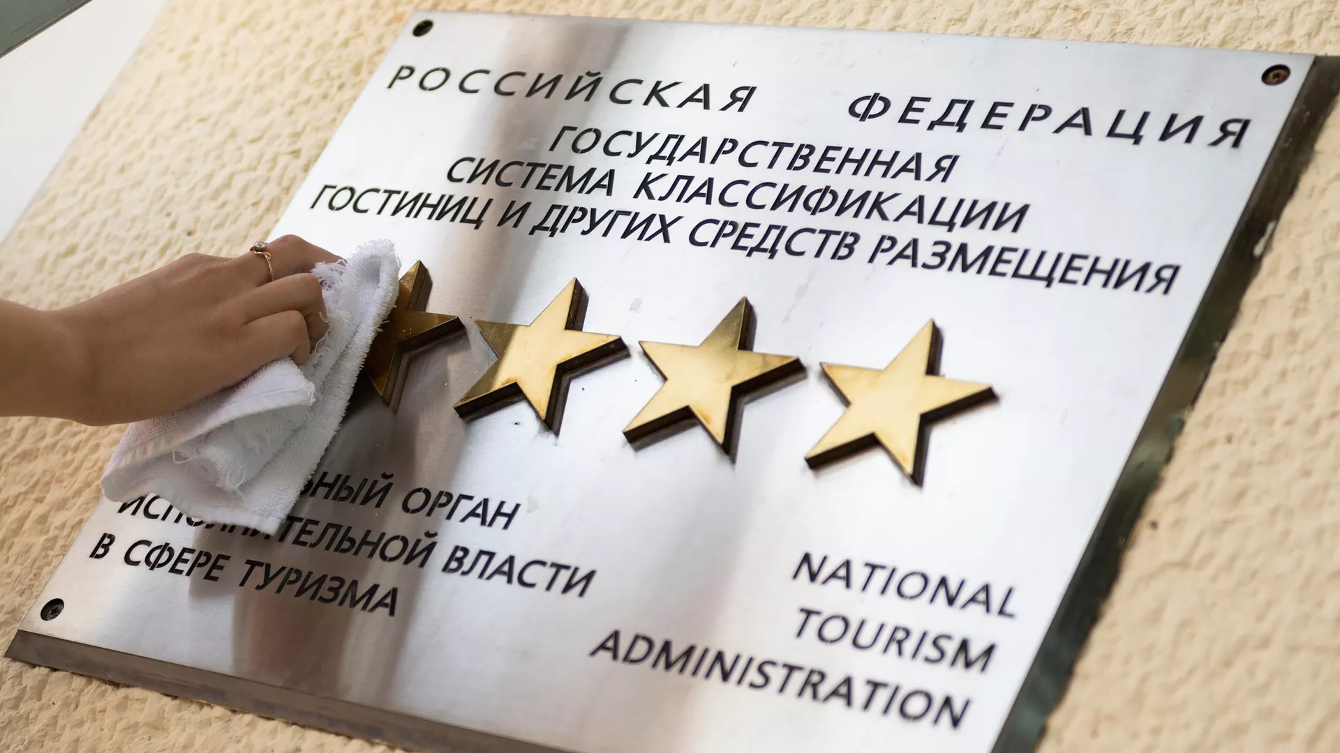 Сотрудница санатория в Сочи чистит табличку звездности на здании отеля - РИА Новости, 1920, 11.10.2023