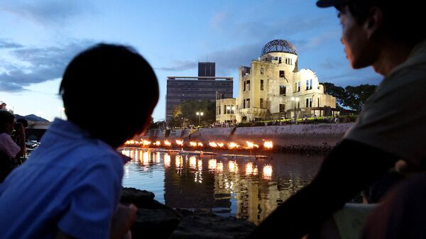 Люди у Купола Гэмбаку во время мероприятий в память о жертвах катастрофы в Хиросиме