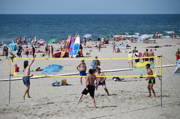 Отдыхающие играют в волейбол на пляже в поселке Янтарный Калининградской области