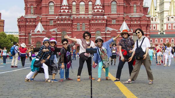 Туристы фотографируются на Красной площади в Москве