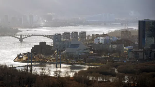Вид на центральную часть Красноярска, Виноградовский пешеходный мост, на остров Татышев и Коммунальный мост через реку Енисей