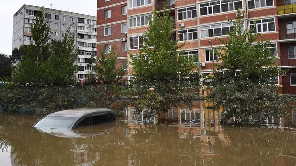 Автомобиль во дворе жилого дома в подтопленном районе Уссурийска. 14 августа 2023