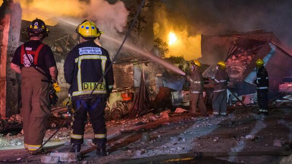 Пожарные тушат пожар после взрыва в доминиканском городе Сан-Кристобаль. 15 августа 2023