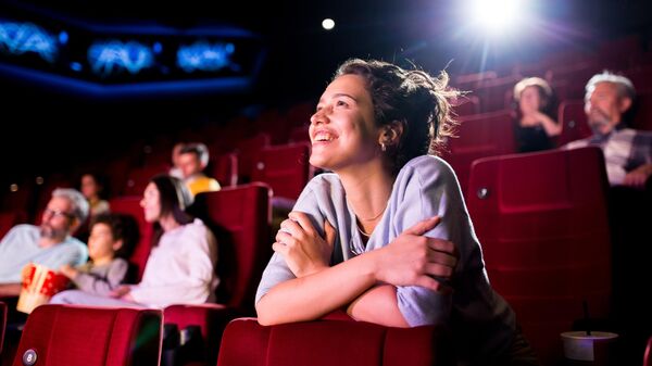 Девушка смотрит фильм в кинотеатре